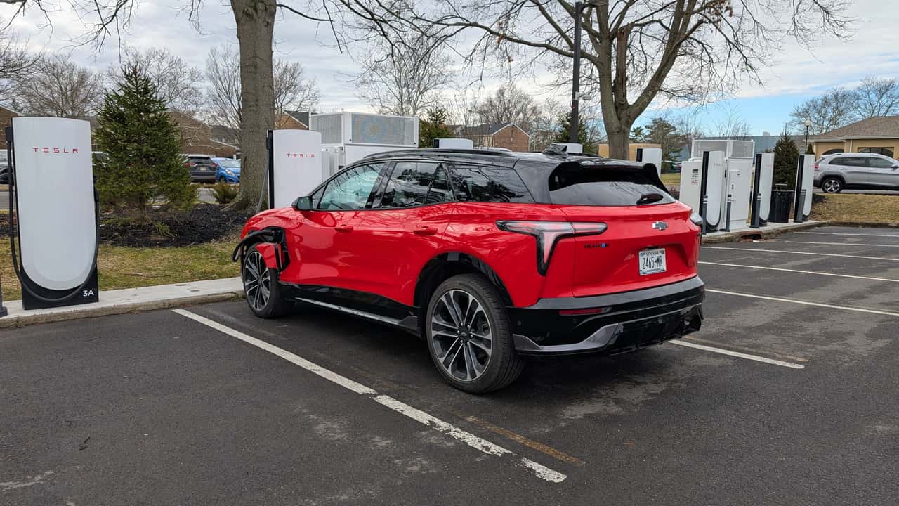 Rød Chevrolet elektrisk SUV parkeret ved Tesla ladestation