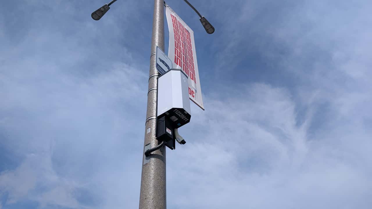 Gadelampe med teknologiudstyr mod blå himmel